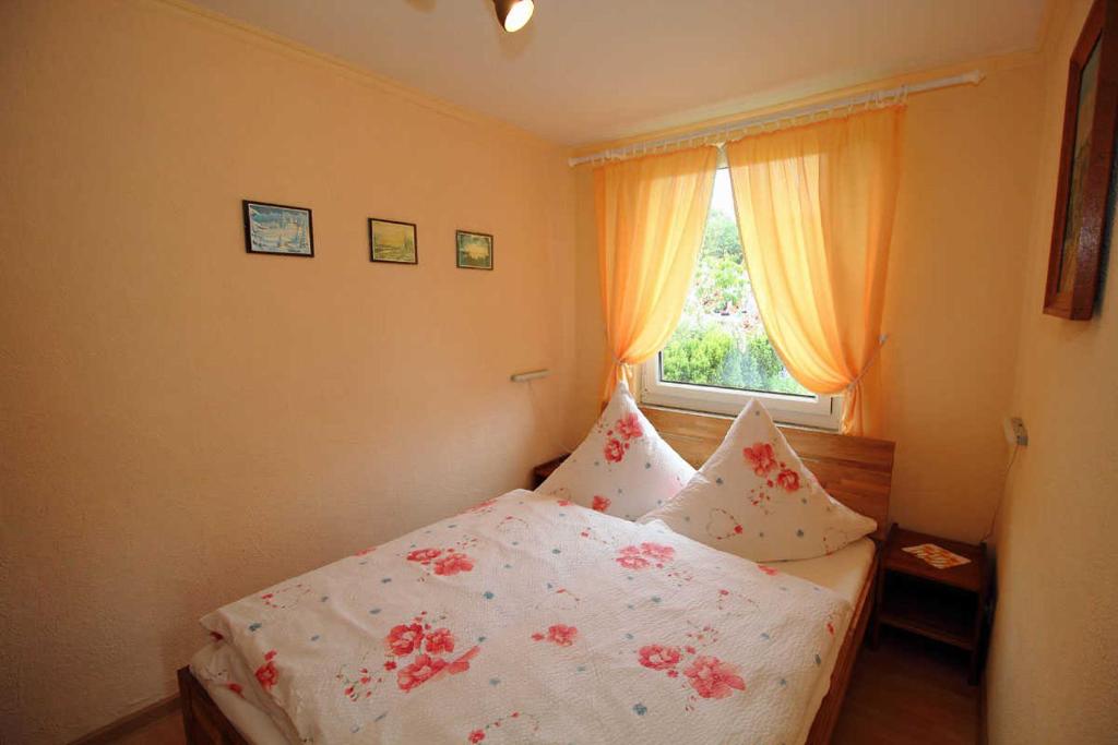 萨斯尼茨Ferienhaus Frisch的卧室配有带鲜花的白色床