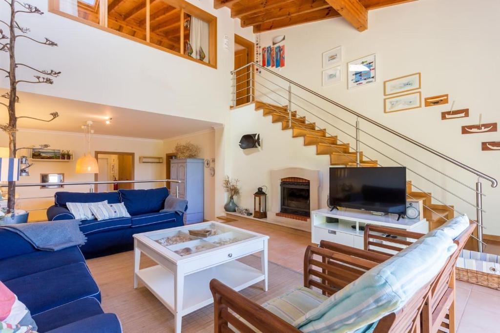 萨格里什Pita's House - Villa Sagres 2的客厅配有蓝色的沙发和电视