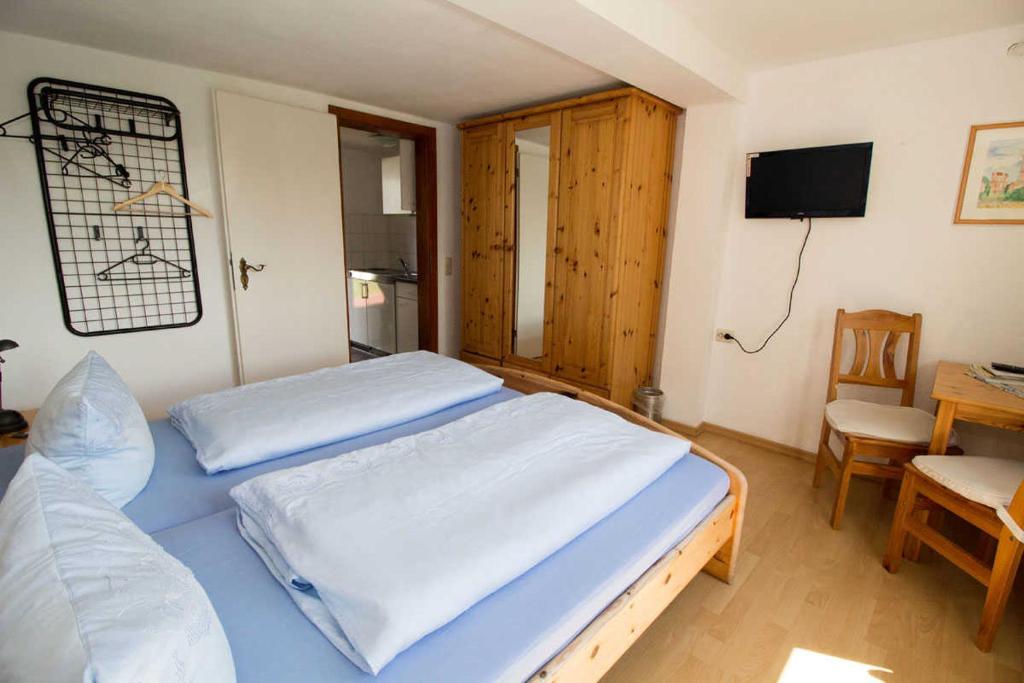 HagenFerienzimmer zum Försterberg的一间卧室配有两张床、一张桌子和一台电视。