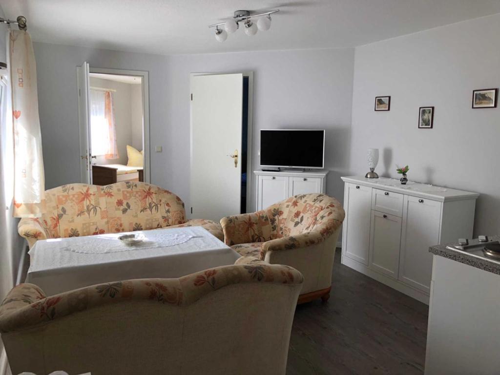 MarlowFerienhaus Karger的客厅配有两把椅子、一张床和电视
