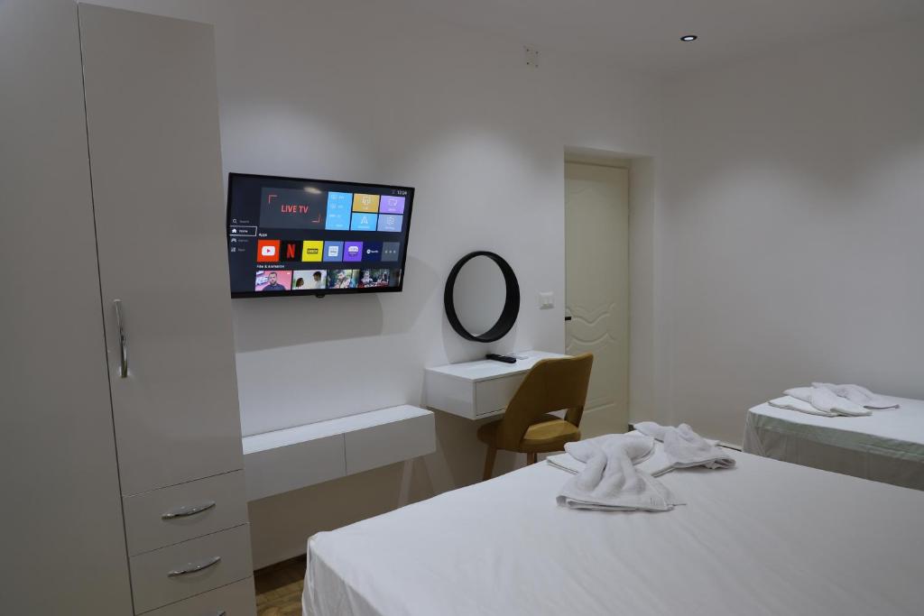 培拉特Noel City Centre Apartment的客房设有两张床和一台墙上的电视。