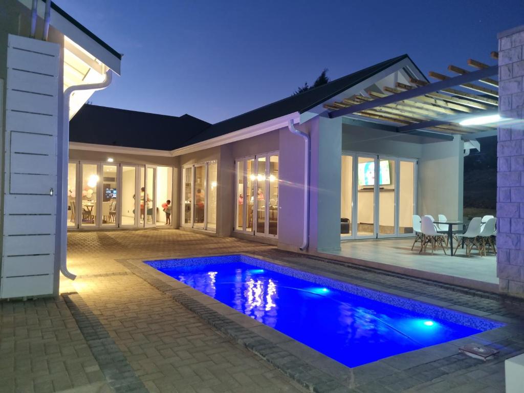 克拉伦斯Villa 206 Clarens Golf Estate的夜间在房子前面的游泳池