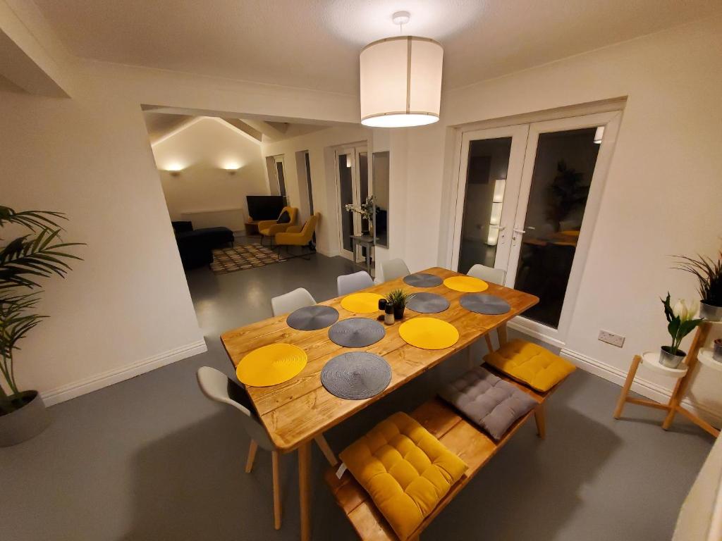 海斯廷斯5 bedroom, recently renovated house close to Hastings Beach的一间带木桌和黄色椅子的用餐室
