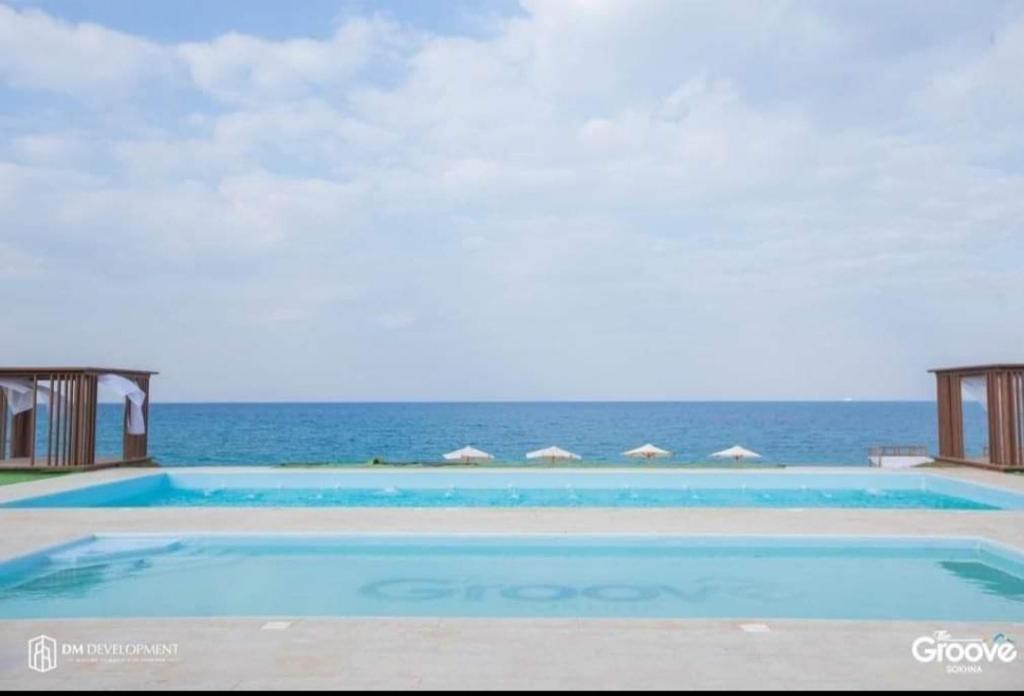 艾因苏赫纳The Groove Ain Sokhna的一个大型的游泳池,背景是大海