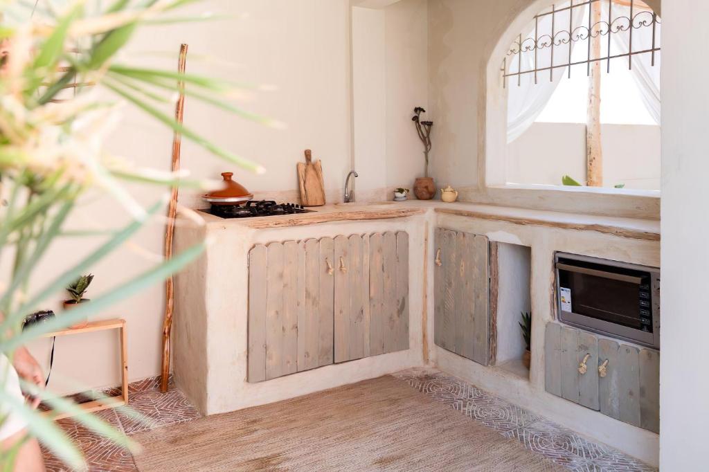 阿加迪尔Desart Hostel的厨房配有木制橱柜、水槽和镜子