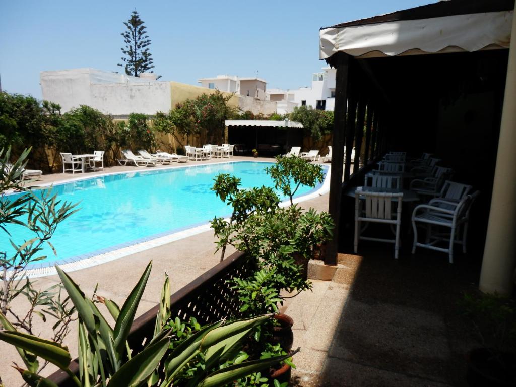 索维拉里亚德扎赫拉酒店的一个带椅子和桌椅的游泳池
