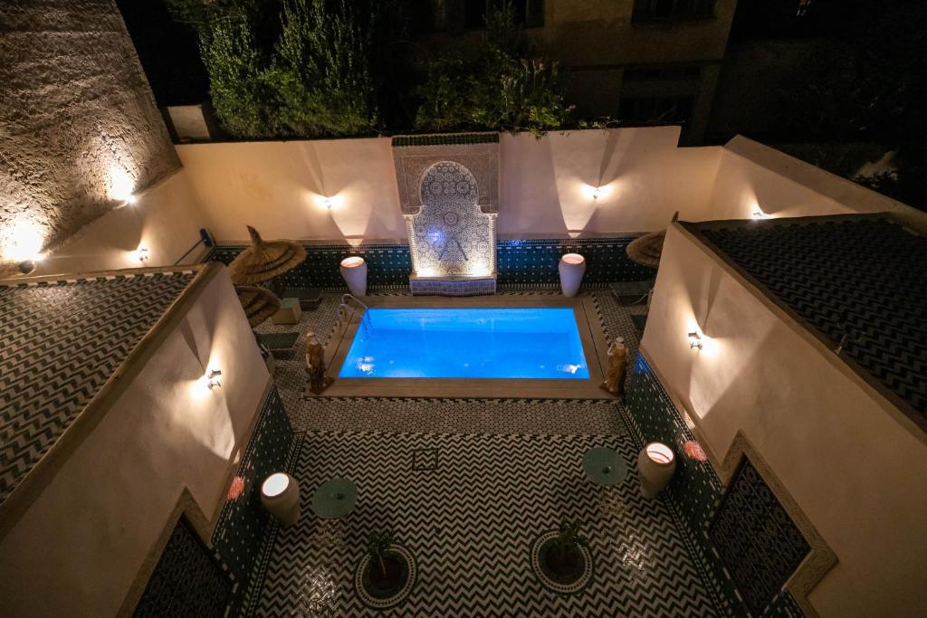 非斯Riad Fes Ziyat & Spa的露天热水浴池,在晚上于庭院里灯火通明