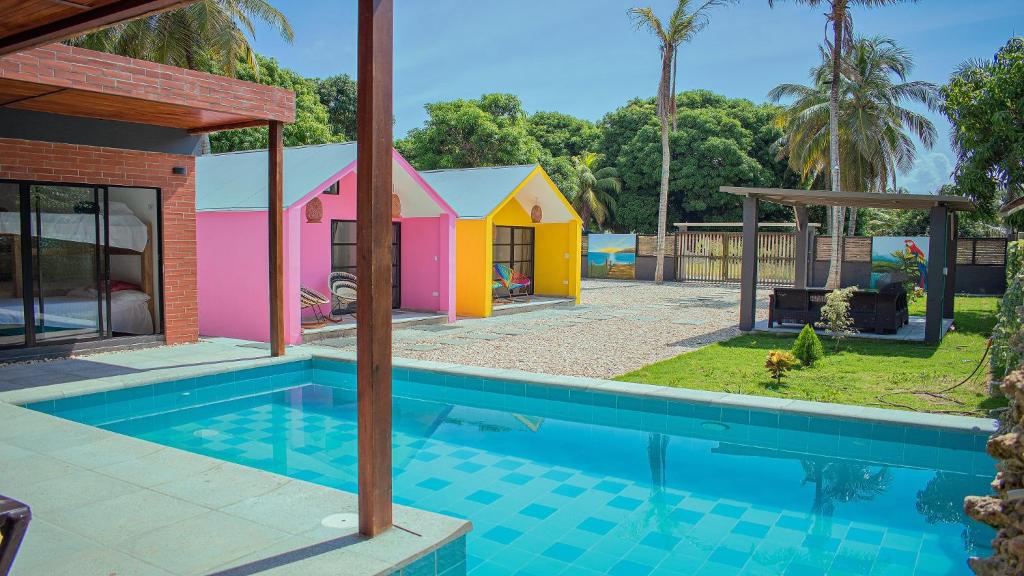 圣贝尔纳多德尔比恩托Cabañas Mambo Beach的一座房子,旁边设有游泳池