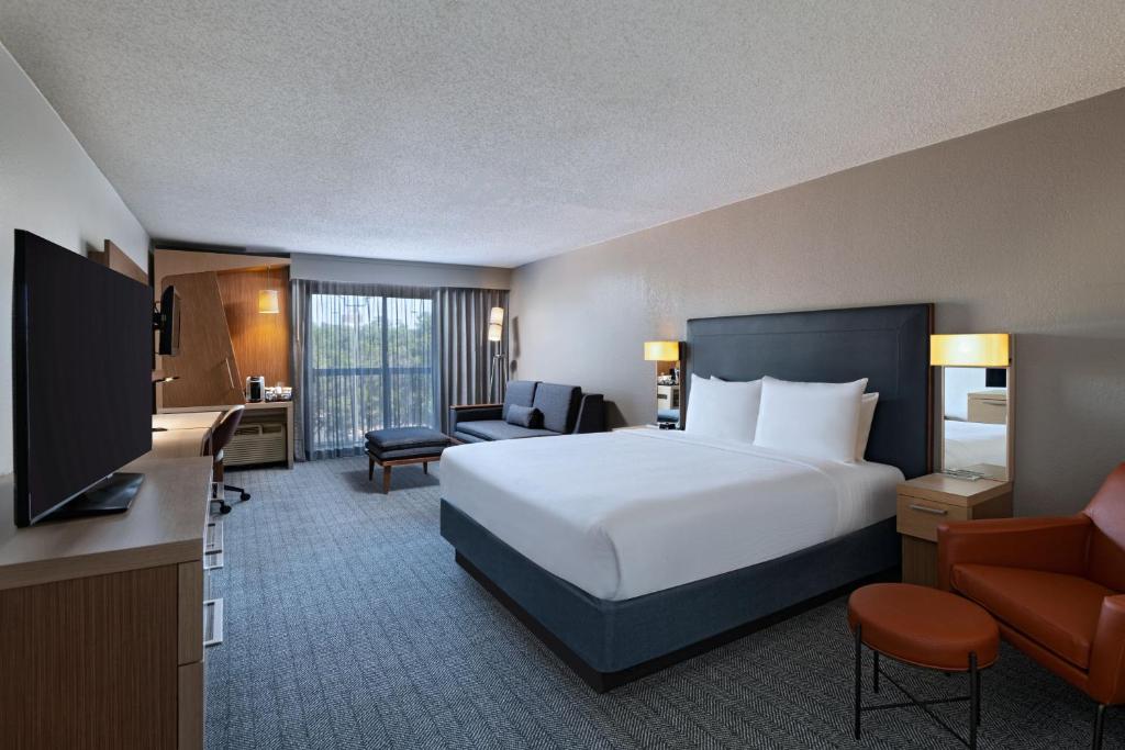 奥斯汀Courtyard by Marriott Austin The Domain Area的酒店客房设有一张大床和一台电视。