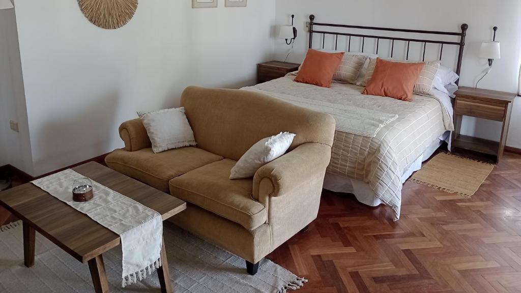 科尔多瓦Nueva Morada的一间卧室配有一张床、一张沙发和一张桌子