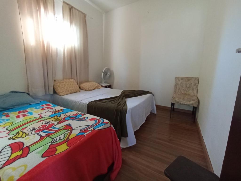 维拉维尔哈Casa pertinho da praia com piscina, wifi;的一间小卧室,配有两张床和椅子