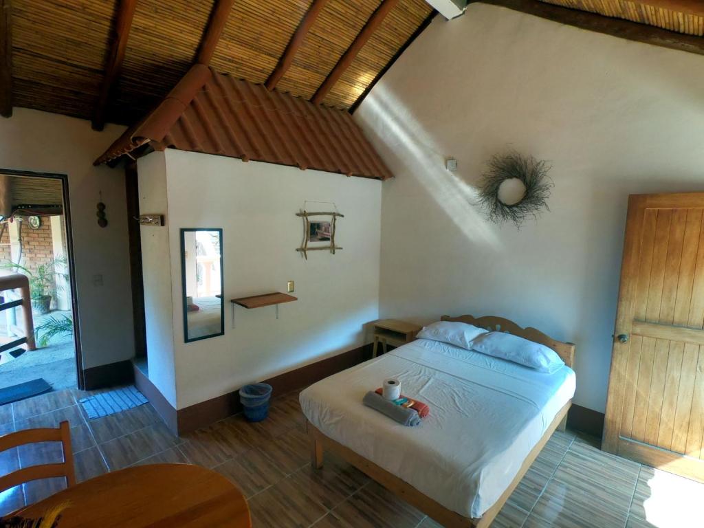 马祖特Casa H Rinconcito Mazunte的卧室配有一张床铺,位于带桌子的房间