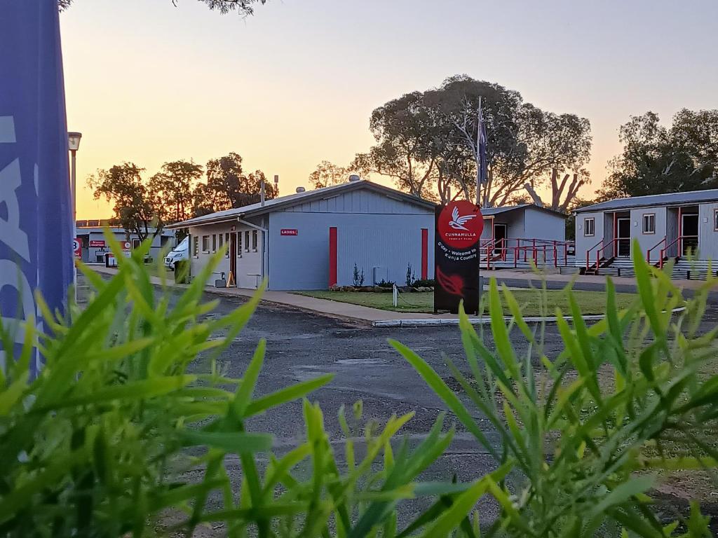 坎纳马拉Cunnamulla Tourist Park的一排建筑物前的古柯可乐标志