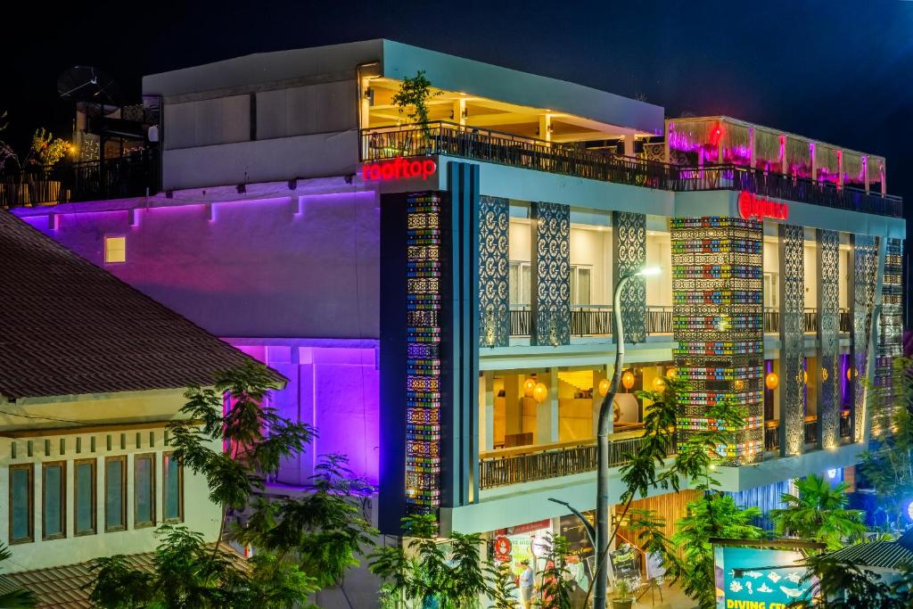 纳闽巴霍DEJAVU 2.0 HOTEL BAJO KOMODO的一座晚上有紫色灯光的建筑
