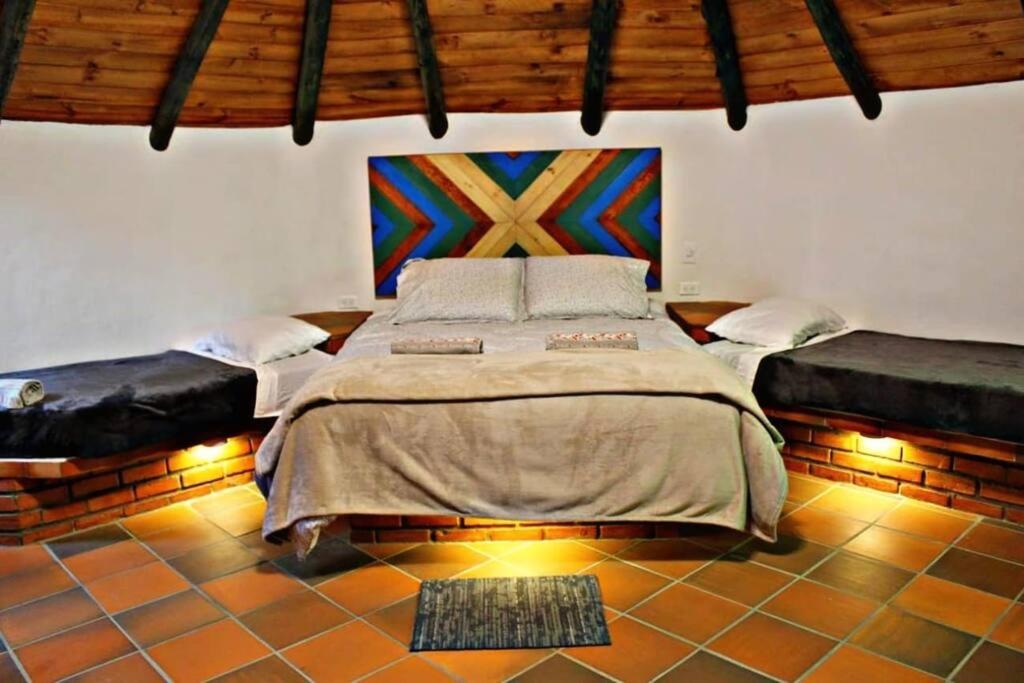 莱瓦镇Ecohotel Buenavista的卧室配有一张床,墙上挂有绘画作品