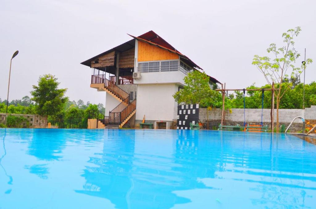 贝鲁沃勒Villa Cinnamon Nature的一座大型游泳池,其建筑背景为: