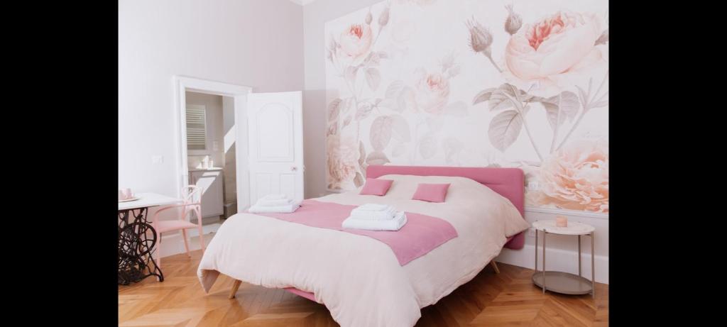 拉弗雷切La Parenthèse Fléchoise, Chambre Agathe的一间卧室设有一张床和粉红色及白色的墙壁