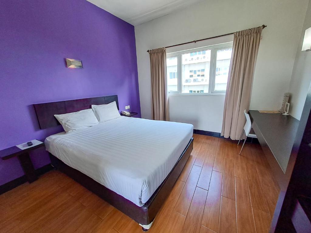 DaresHOTEL TILAMAS的卧室配有白色的床和紫色墙壁