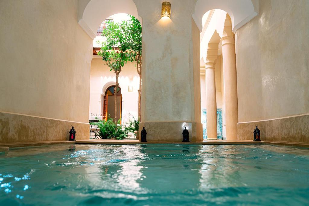 马拉喀什Riad Dar Zaouia的一座有树的建筑中的游泳池