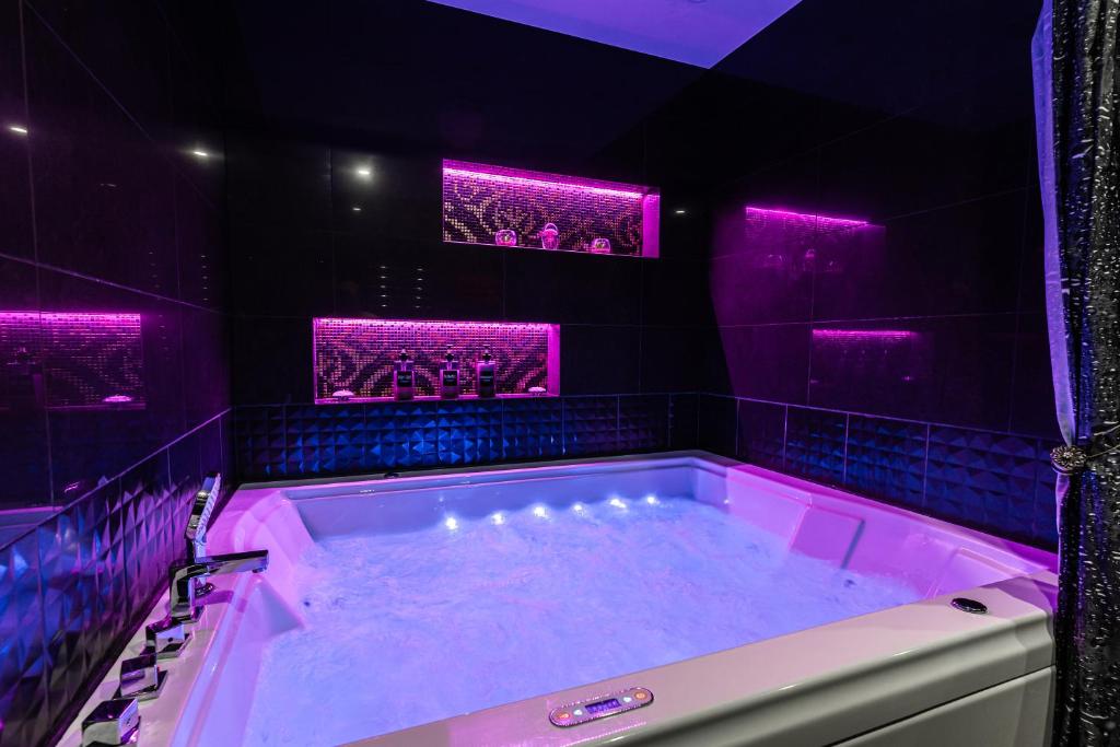 塔林LuxeCityApartment的紫色浴室设有紫色灯浴缸