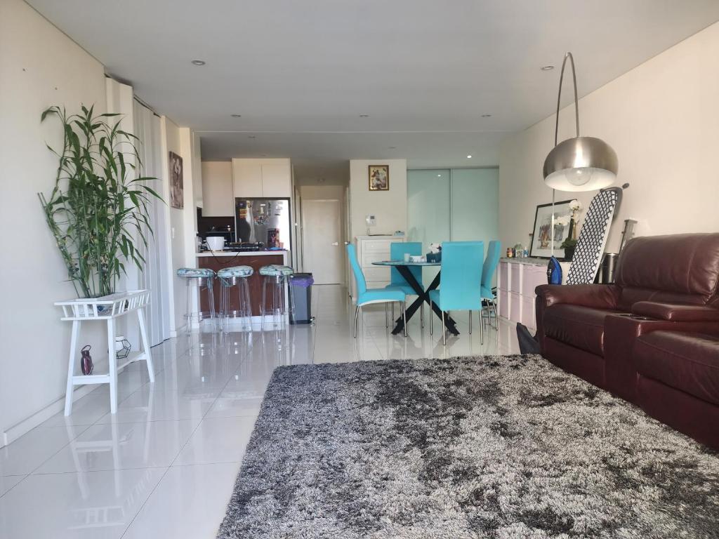 悉尼Parramatta Shared Apartment的客厅配有沙发和桌子