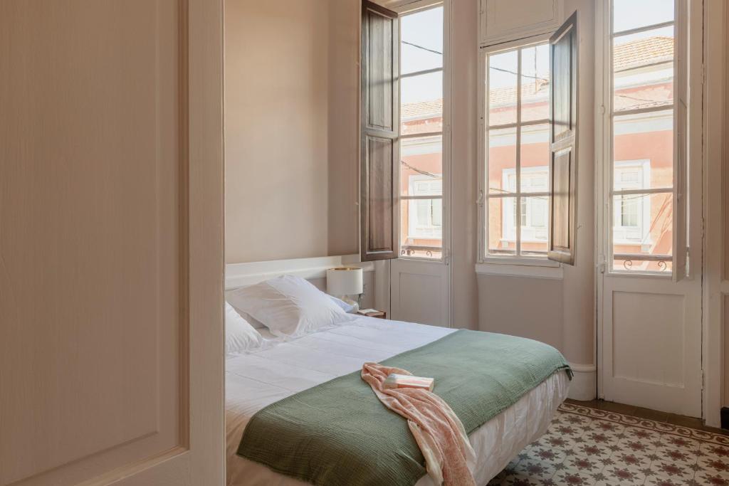 拉拉古纳El Ombú del Agua的一间卧室设有一张床和两个窗户。