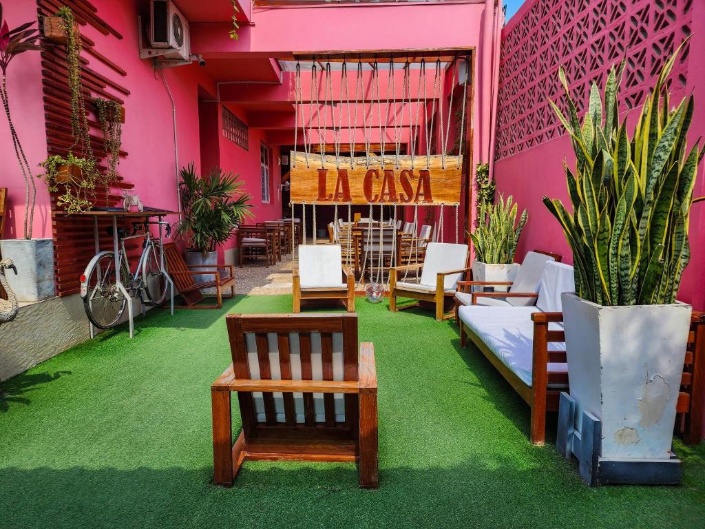 马普托La Casa Moz的餐厅拥有粉红色的墙壁,配有椅子和植物