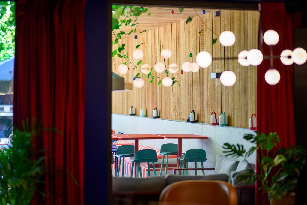 斯特拉斯堡ClapClap Hôtel, Food & Bar的用餐室配有桌椅和灯