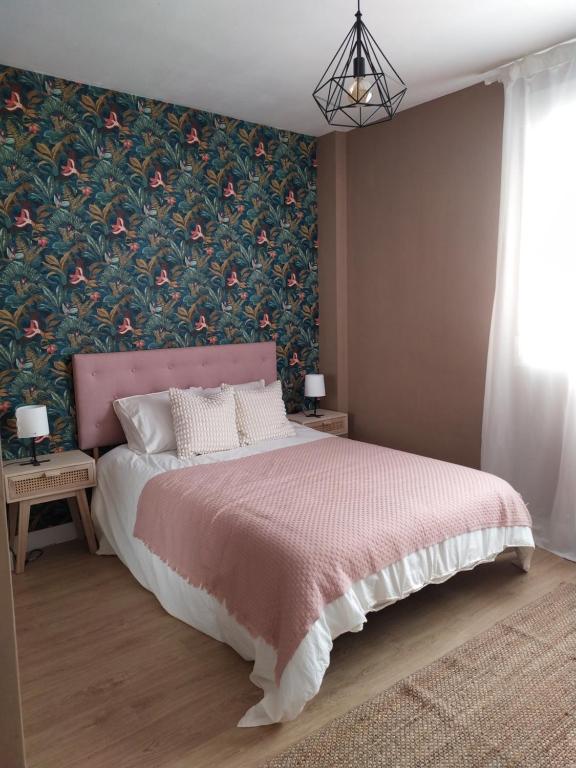 曼萨纳雷斯DIVINA GUEST HOUSE的卧室配有粉红色的床和花卉壁纸