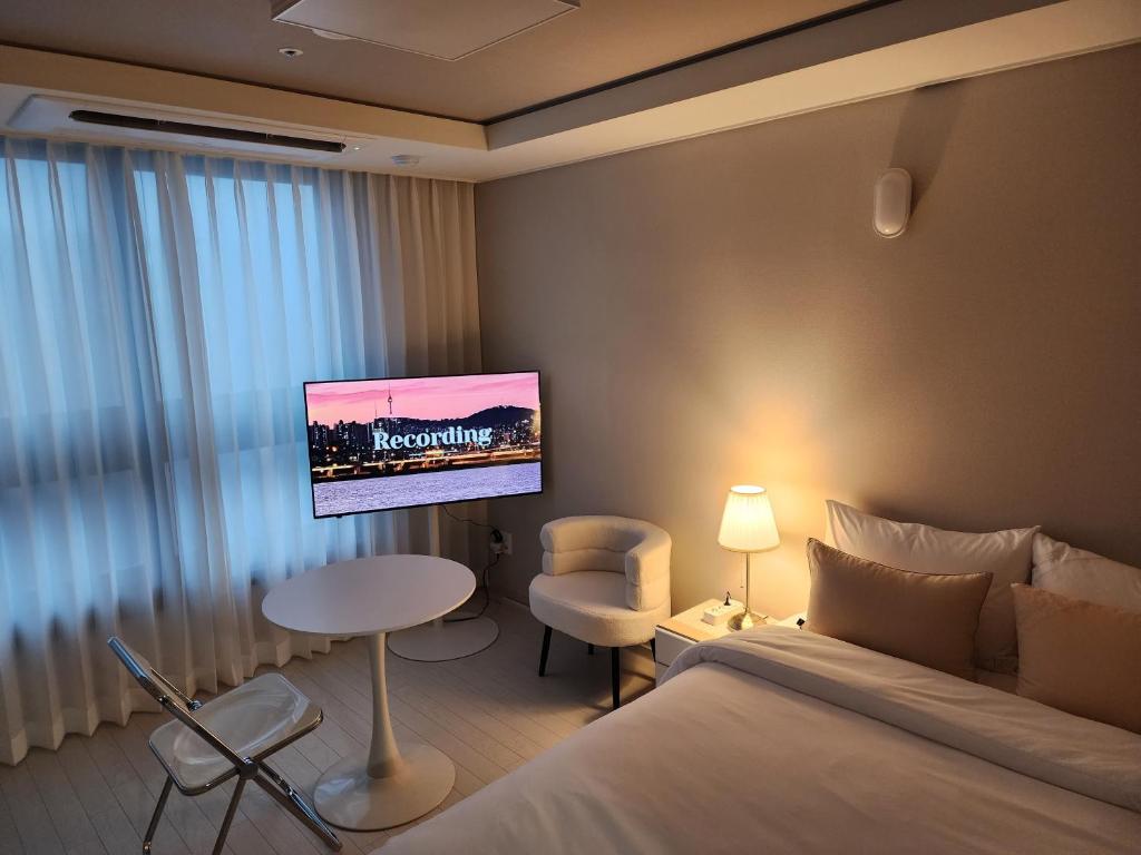 大邱동성로 Residence Daon的酒店客房设有一张床和墙上的电视