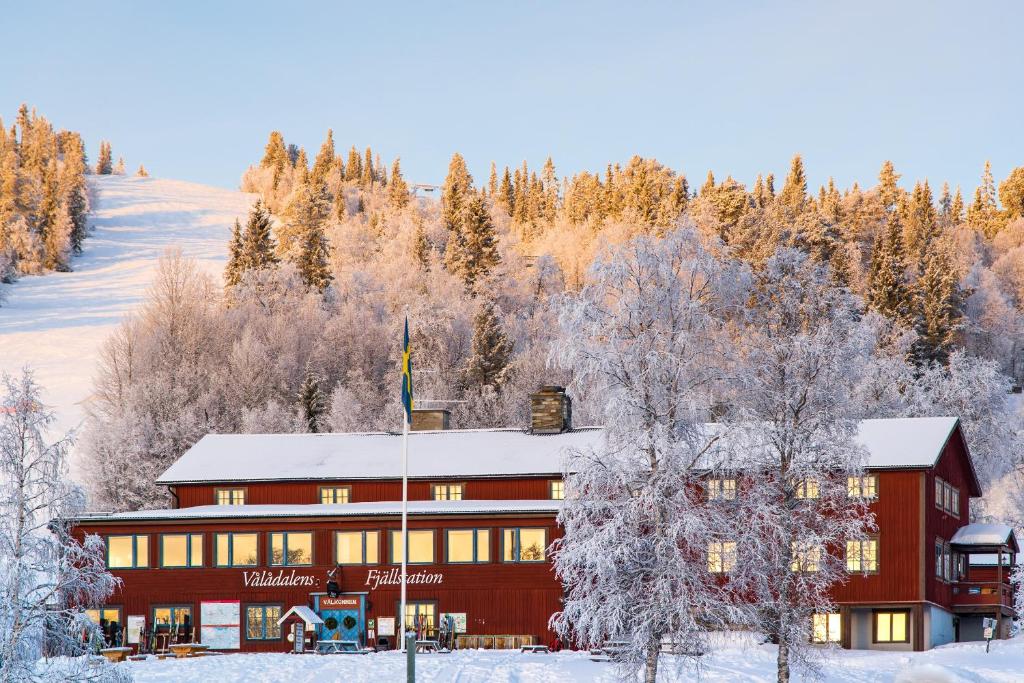 Vålådalen瓦拉达兰斯车站旅馆的一座大红的雪地建筑,有树木