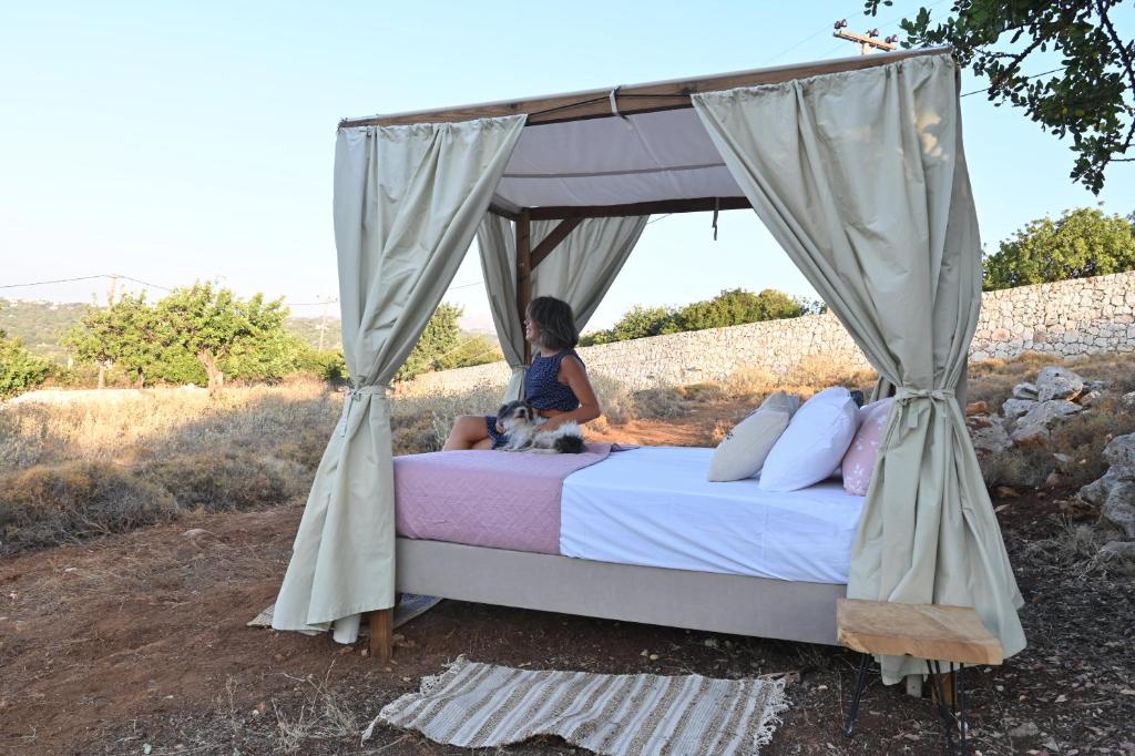 YeránionStar Sleep Gerani Rethymno的坐在天篷下床边的女人