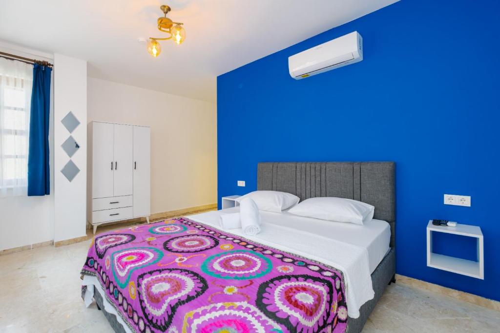安塔利亚Mel Town的一间卧室设有一张蓝色墙壁的大床