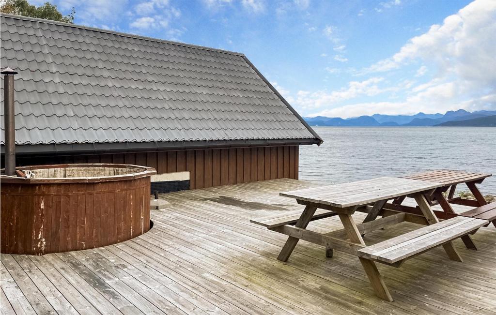 MidsundNice Home In Midsund With Kitchen的热水浴池旁甲板上的两张野餐桌