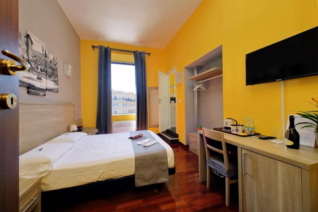 罗马LHG Comfy Rooms的酒店客房设有一张大床和一张书桌。