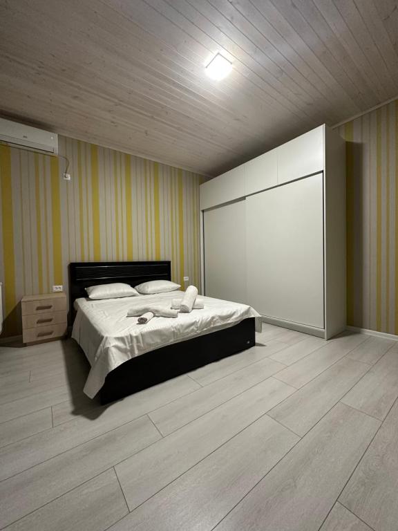 第比利斯Guesthouse Chrdili的卧室配有床和大屏幕白色屏风