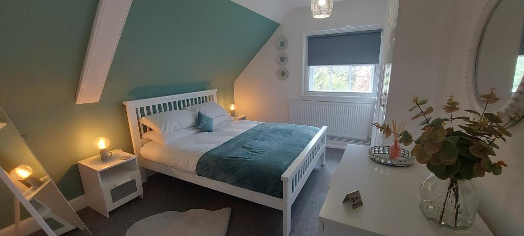 坎诺克Gilpin Suite的卧室配有白色的床和窗户。