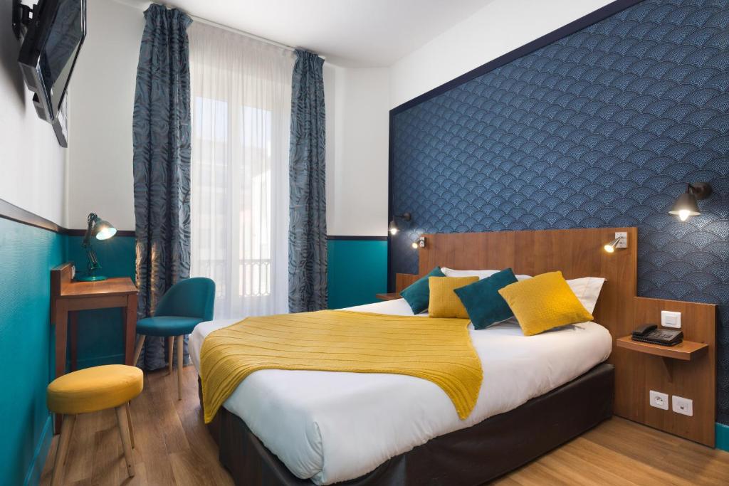尼斯快乐文化拿普酒店的一间卧室设有一张大床和蓝色的墙壁
