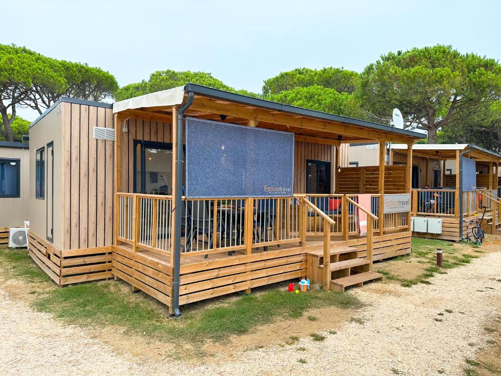 利多迪耶索罗Estivo Premium Deluxe mobile homes on Camping Malibu Beach的大型小木屋设有大型屏蔽门廊