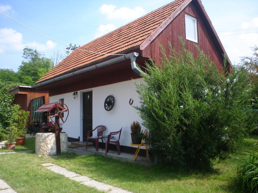 TrávnicaPodhajska ubytovanie - D&B Konecna的红色和白色的房子,配有桌子和椅子