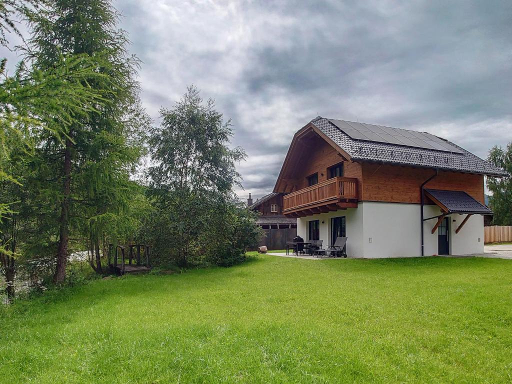 玛丽亚普法尔AlpiNest Feriendorf Lungau的一间房子,有 ⁇ 帽屋顶和绿色庭院