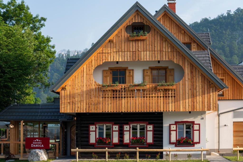 博希尼Guesthouse & Camping Danica Bohinj的一间木房子,设有 ⁇ 盖屋顶