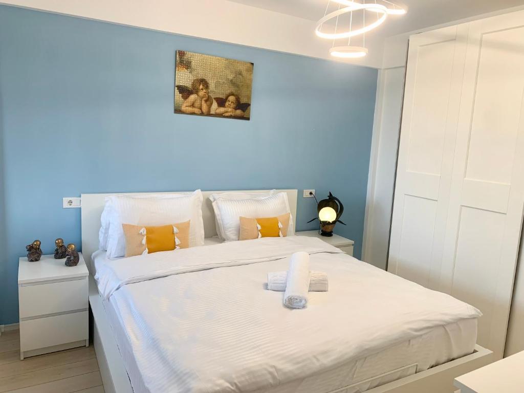 布拉索夫JAD - Comfortable Family Apartments - Coresi的卧室配有白色床和蓝色墙壁