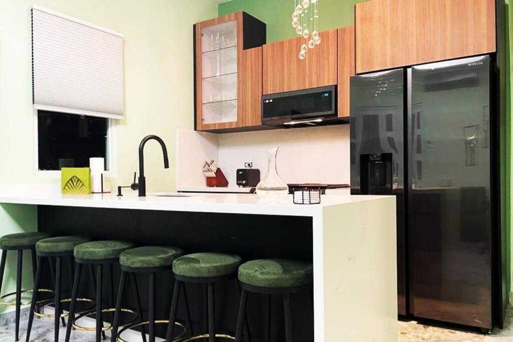 圣胡安Casa Verde - Modern Apt in Santurce's Art District in San Juan的厨房配有带绿色凳子的吧台