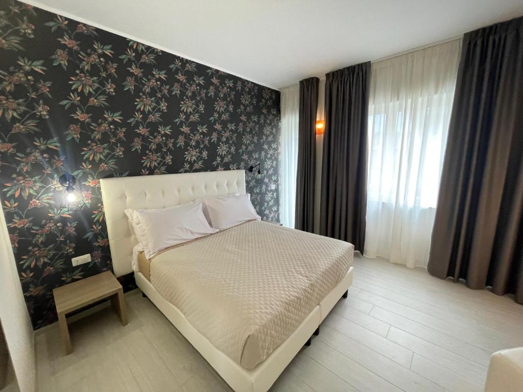 菲乌米奇诺Castrichella Boutique Hotel Rome Airport的一间卧室设有一张床和鲜花墙
