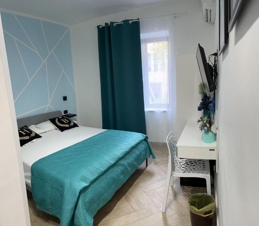 那不勒斯巴巴托酒店的一间卧室配有一张床、一张书桌和一个窗户。