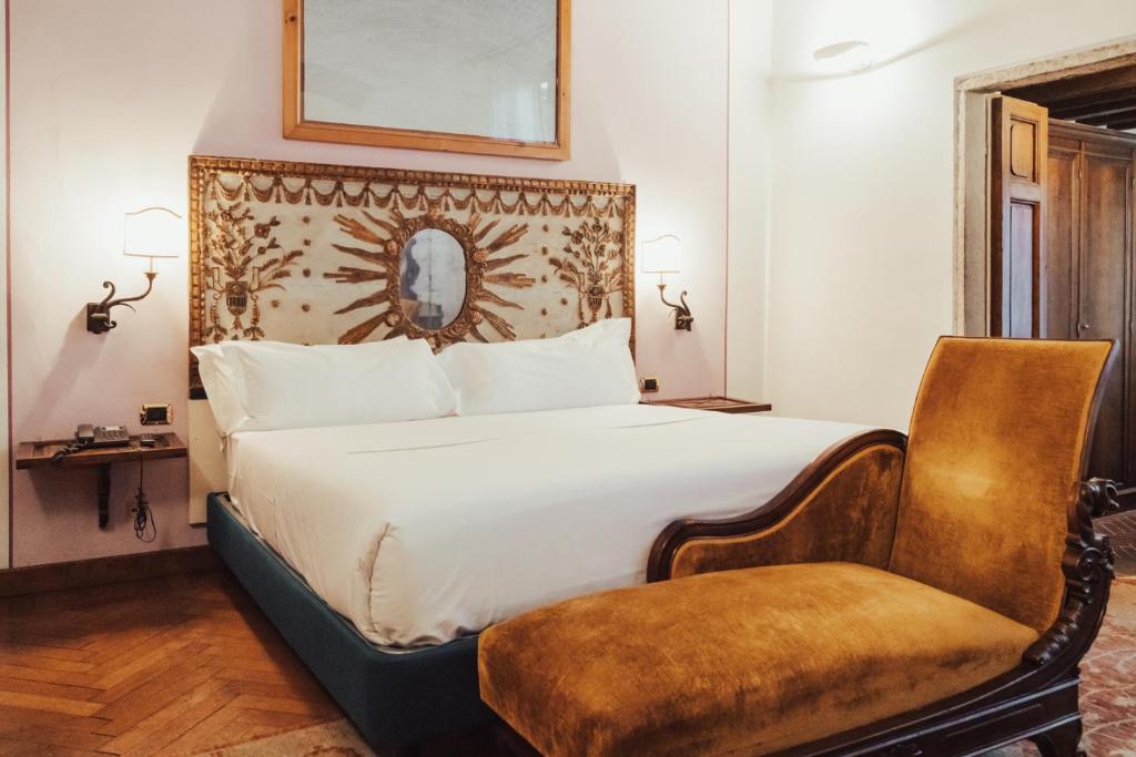 佛罗伦萨II Guelfo Bianco的配有一张床和一把椅子的酒店客房