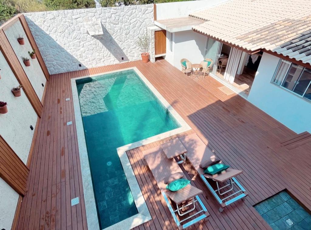 弗洛里亚诺波利斯Casa com piscina climatizada em frente à Praia do Santinho的木制甲板上享有游泳池的顶部景致