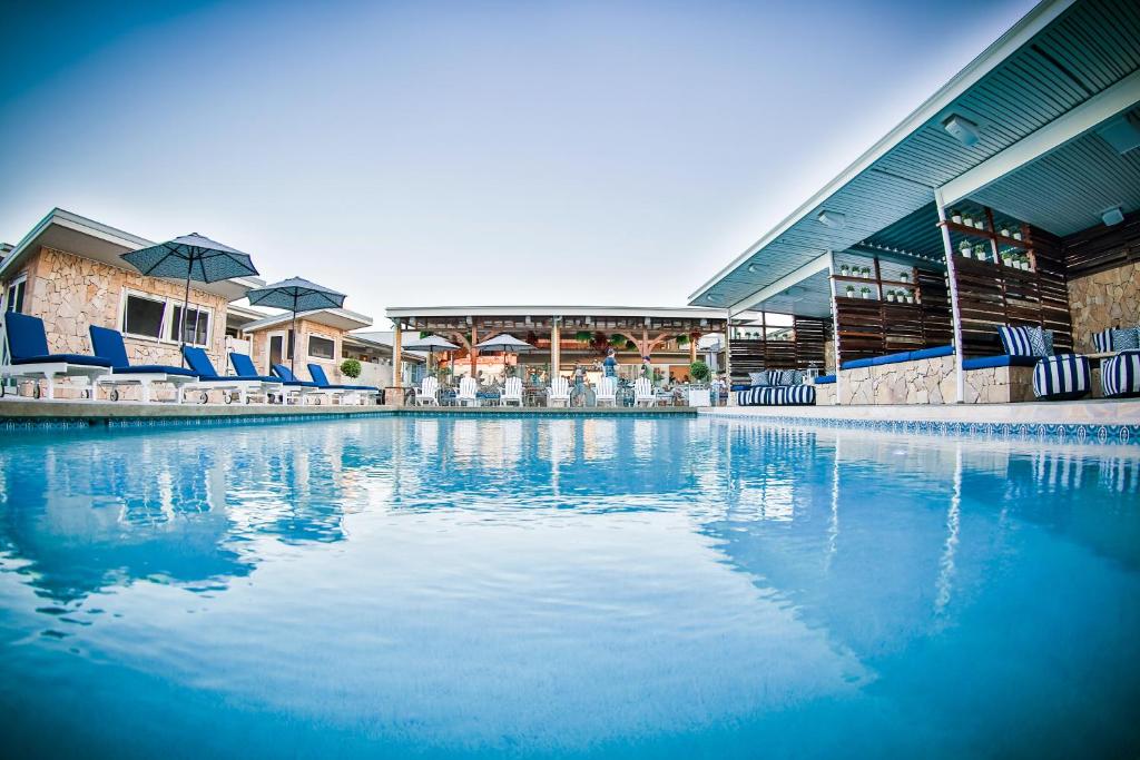 汤斯维尔Rambutan Resort的一座带蓝色椅子的游泳池和一座建筑