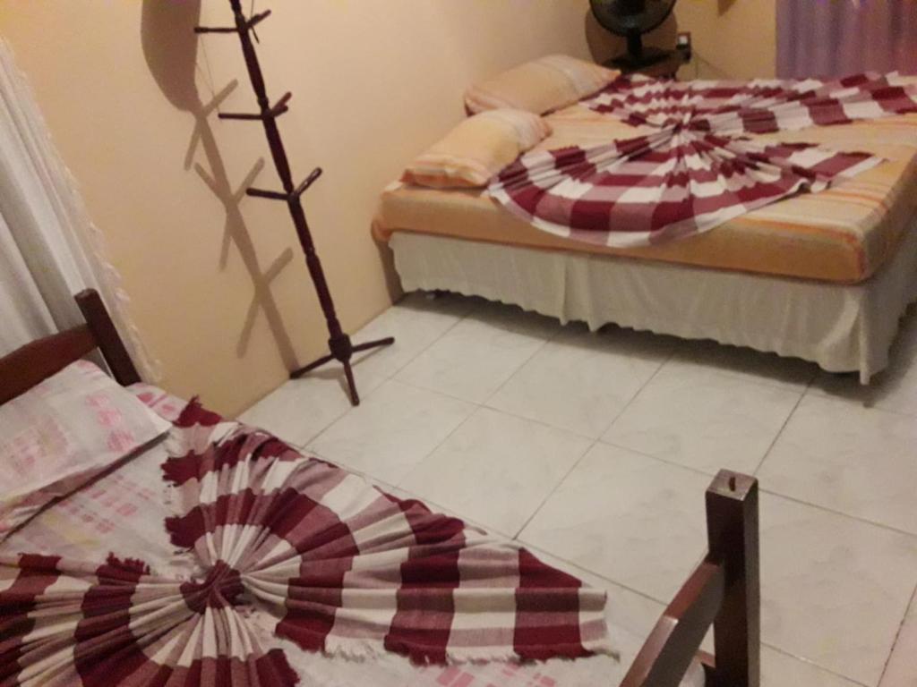 马里卡Casa temporada maricá的一间卧室配有两张床和一张带风扇的桌子。